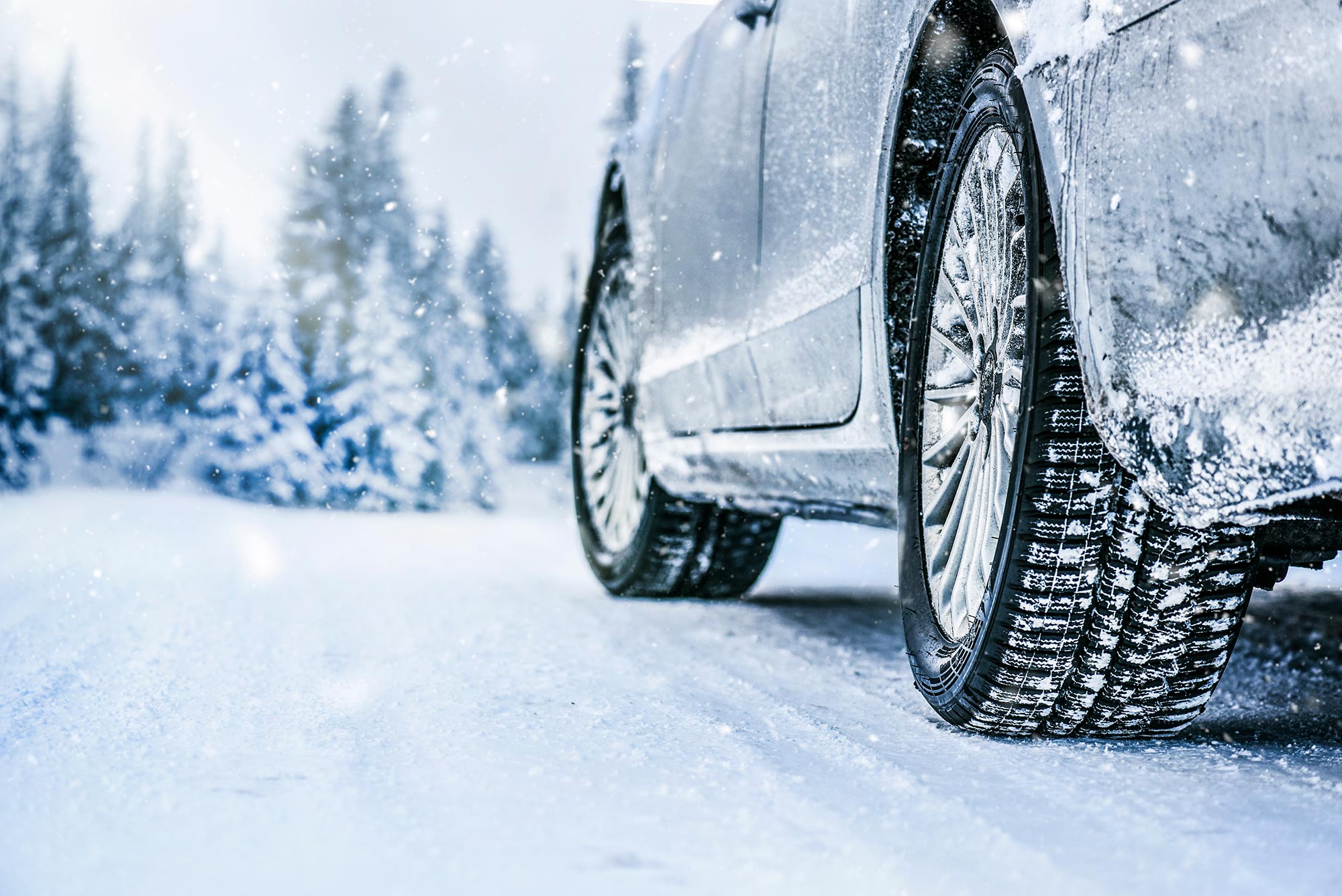 Photo of close up of car driver's side tires on a winter road